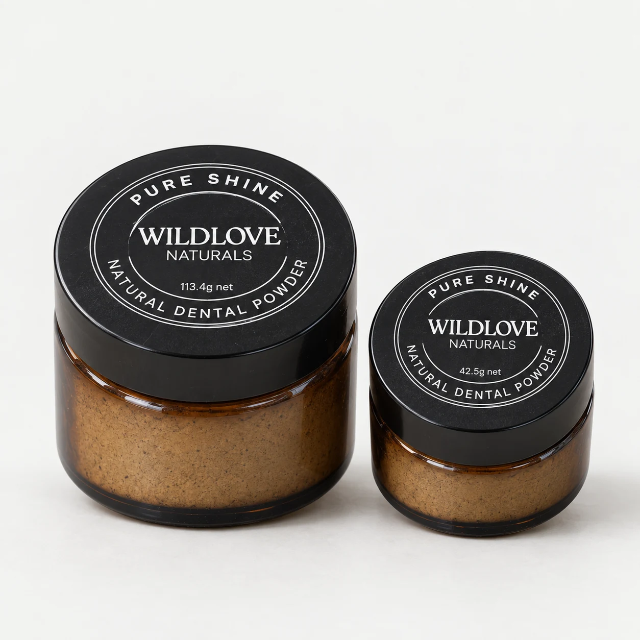 Wildlove Naturals Pure Shine dental powder in small and large amber glass jars with black lids